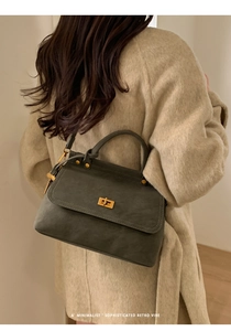Detail view of the vintage grey textured leather handbag with gold metal twist lock closure