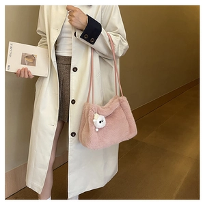 Dettaglio borsa a secchiello rosa in ecopelliccia con ciondolo e tracolla sottile