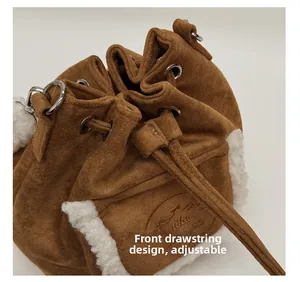 Detail of dark brown suede bucket bag with white faux shearling trim and drawstring close
