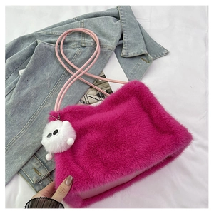 Dettaglio borsa a secchiello in peluche rosa con tracolla in pelle e ciondolo pompon