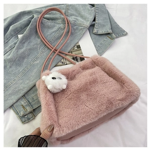 Dettaglio della borsa a secchiello rosa in ecopelliccia con spalline in pelle e ciondolo