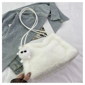 Dettaglio della borsa a secchiello in morbido peluche bianco con ciondolo a forma di mostro