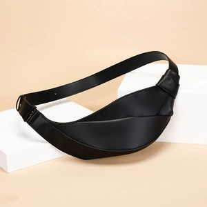 Detailed view of black pleated croissant bag texture on soft beige background