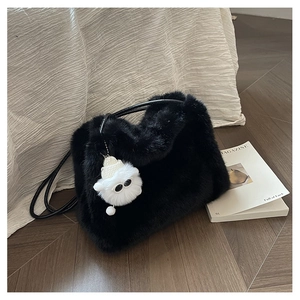Dettaglio borsa a secchiello in ecopelliccia nera con ciondolo mostro bianco in peluche