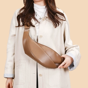 Detailed macro view of brown leather croissant bag with stylish wide adjustable strap