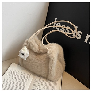 Dettaglio della borsa a secchiello in peluche beige con texture in ecopelliccia e orsetto