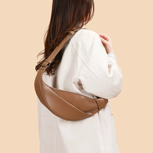 Close-up of brown matte leather croissant bag showing a stylish half-moon shape design