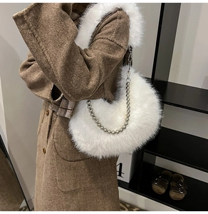 Detailed texture of white plush crescent bag with decorative silver beaded chain strap