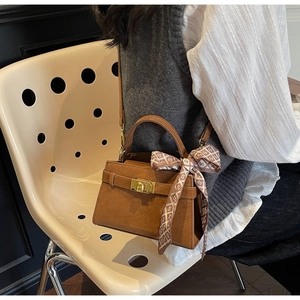 Sac à main en daim marron avec fermoir doré et foulard en soie en vue lifestyle