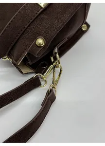 Detail view of brown faux leather shoulder bag with detachable gold metal hook clasp