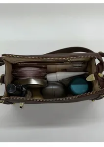 Top view of brown shoulder bag interior showing storage space for phone and makeup