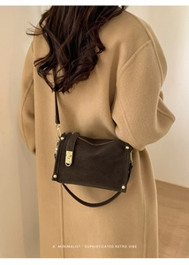 Detail of retro brown suede crossbody bag with gold hardware and rivet decorations