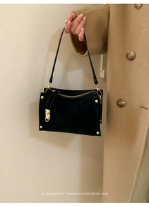 Detailed view of black vintage shoulder bag with premium gold hardware and soft suede texture