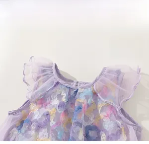 Detail of purple tulle dress with colorful 3D flower accents and ruffled shoulders