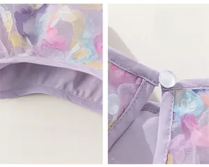 Detail of purple tulle dress with 3D floral accents and ruffle sleeves and pearl button