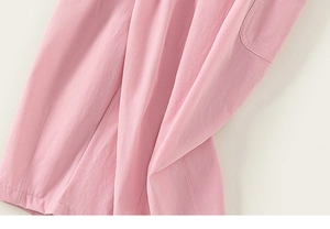 Close-up of pink girls' cotton trousers showing side pocket and fine stitching detail
