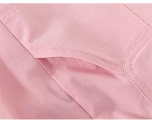 Detailed macro view of pink cotton trousers showing precise double-stitched pocket seams