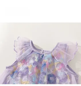 Detail of purple tulle dress with colorful 3D mesh floral appliques and ruffled neckline