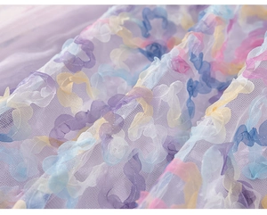 Macro detail of 3D macaron flower appliques on purple tulle fairy dress