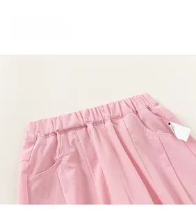 Detail showing elastic gathered waistband and side pockets on pink cotton girls' pants