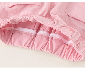 Detailed close-up of elastic waistband with white reinforced piping on pink cotton trousers