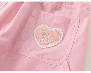 Detailed macro view of heart embroidery with lace trim and Butter bear text on pink pants