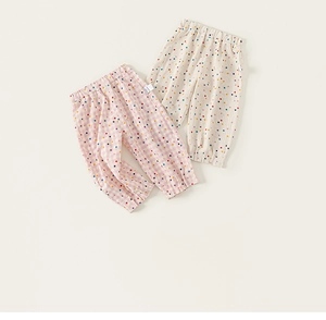 Détail de pantalons pour tout-petits à carreaux roses et blancs avec pois colorés et taille élastique