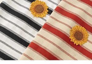 Détail de tissu rayé en coton-lin avec écussons tournesol brodés sur hauts pour enfants