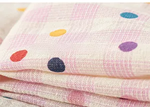 Détail du tissu en gaze de coton multicouche avec pois colorés et motif à carreaux rose