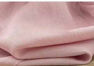 Close-up of pink textile fabric with soft woven texture and natural sheen on casual shorts