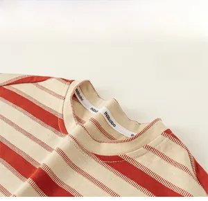 Détail du col d'un t-shirt à rayures rouges avec coutures de qualité et ruban tissé