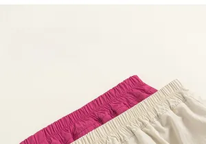 Detail view of elastic waistbands on rose red and beige cargo shorts for kids