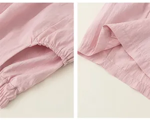 Detail of pink woven cargo shorts featuring elastic waistband and reinforced pocket stitching