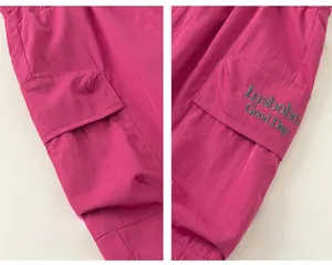 Detailed view of the rose red cargo shorts featuring side flap pocket and letter embroidery
