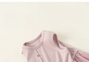 Dettaglio macro di abito rosa senza maniche in maglia a coste con bottone metallico