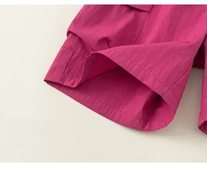 Detailed view of magenta cargo shorts fabric texture with professional reinforced stitching