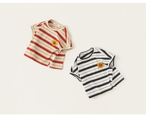 Détail à plat de t-shirts rayés pour tout-petits avec broderie de tournesol au centre