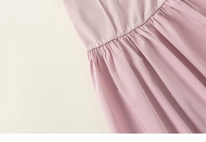Dettaglio dell'abito rosa smanicato con top a costine e vita plissettata della gonna