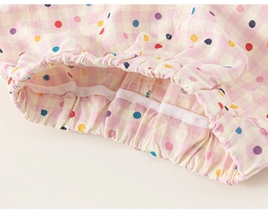 Détail du pantalon à carreaux rose avec pois colorés, taille élastique et coutures fines