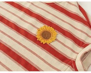 Détail d'un t-shirt rayé rouge et blanc avec broderie tournesol et coutures de l'encolure