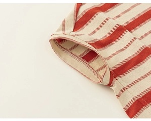 Détail du revers de manche rayé rouge et blanc avec couture à double aiguille de qualité