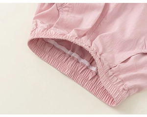 Detail of a pink elastic waistband on lightweight woven casual shorts for children