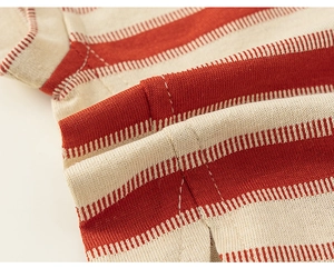 Détail d'un haut en maille rayé rouge et blanc montrant la fente latérale et la couture