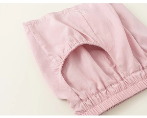 Detail of pink cotton shorts showing elastic waistband and stitching on side pocket