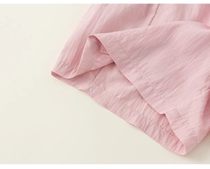 Detail view of pink kids' cargo shorts showing breathable fabric texture and fine stitching