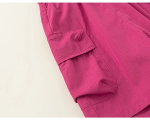 Detail of rose red cargo pants featuring a flap pocket with premium stitching quality