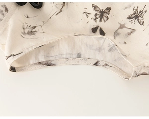 Detailed macro view of ink butterfly print on sleeveless cotton-linen dress with piping
