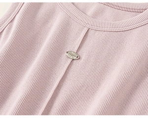 Dettaglio canotta in maglia a coste rosa con scollo rotondo e targhetta in metallo vogue