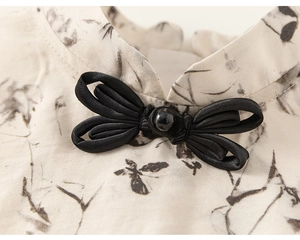 Detail of mandarin collar with black butterfly frog button on ink print girls dress