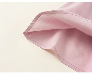 Dettaglio dell'orlo dell'abito rosa senza maniche da bambina con cuciture e trama tessuta